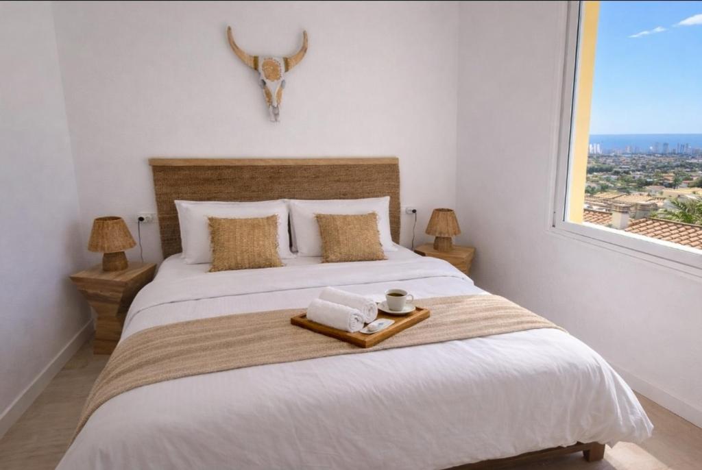 a bedroom with a large bed with a tray of towels at Casa MuMa in Calpe