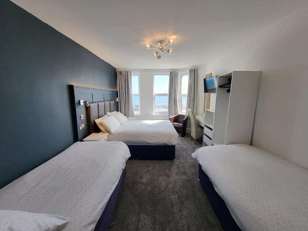 a hotel room with two beds and a window at At Caledonia in Douglas