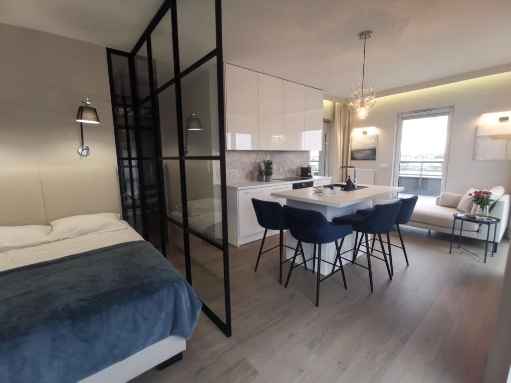 a bedroom with a bed and a kitchen with a sink at Sunset Terrace Wrocław Stadion in Wrocław