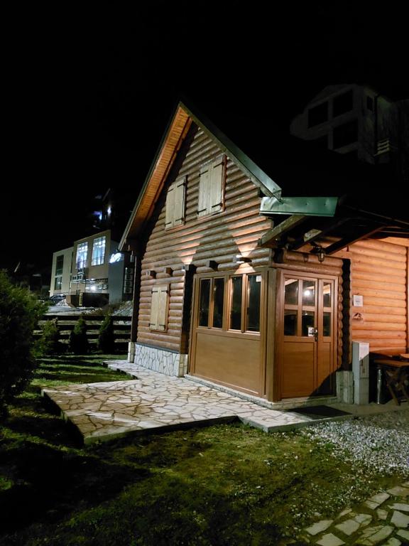 a wooden house with a garage at night at Zara Chalet in Kolašin