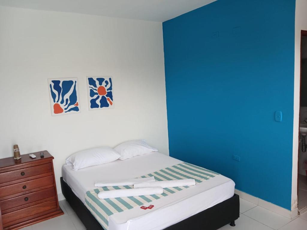a bedroom with a bed and a blue wall at AMAREA Hotel Boutique in Tolú