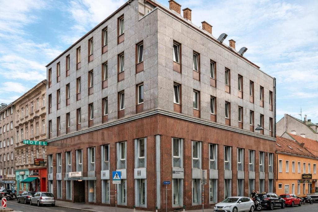 a large brick building on a city street at Hotel George Vienna in Vienna