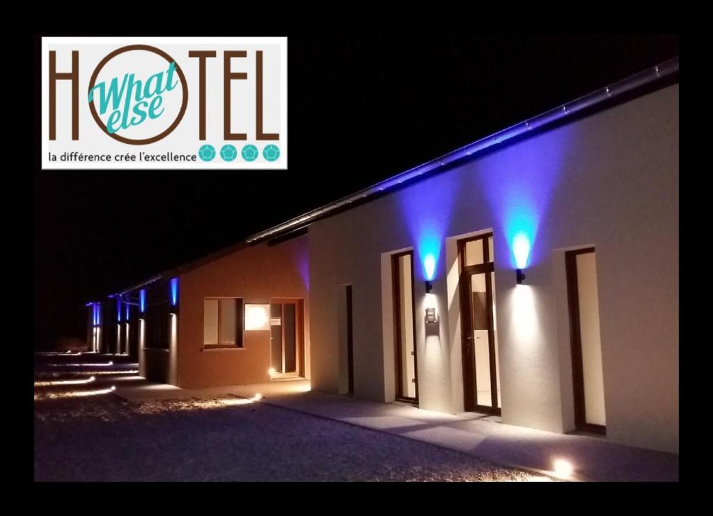un edificio con luces azules en el lateral en What Else Hotel, en Saint-Vulbas