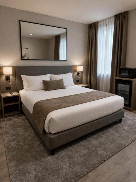 a bedroom with a large bed with a large mirror at Hôtel Le Castanea Entre Aurillac et Marcolès Auvergne in Roannes-Saint-Mary