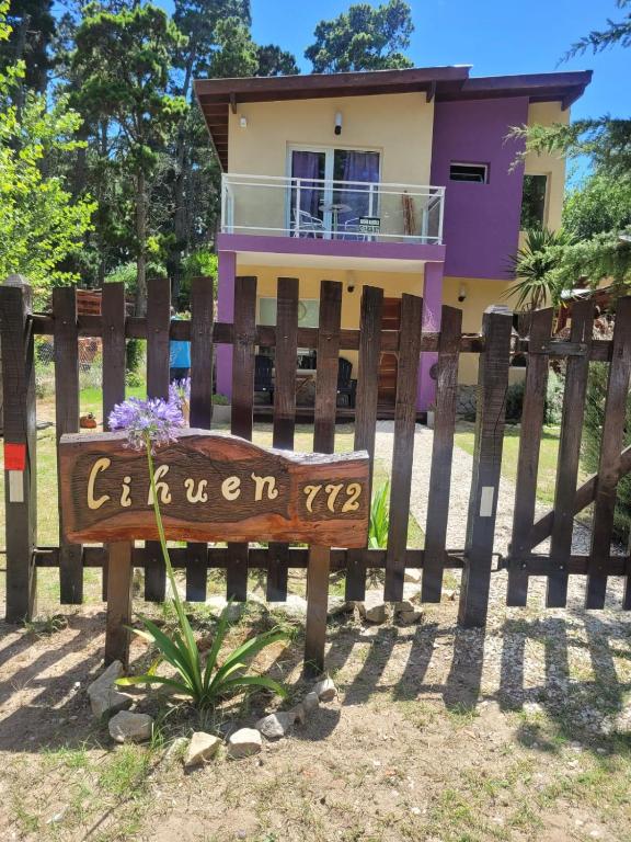 a house with a sign in front of a fence at Lihuen in Mar Azul