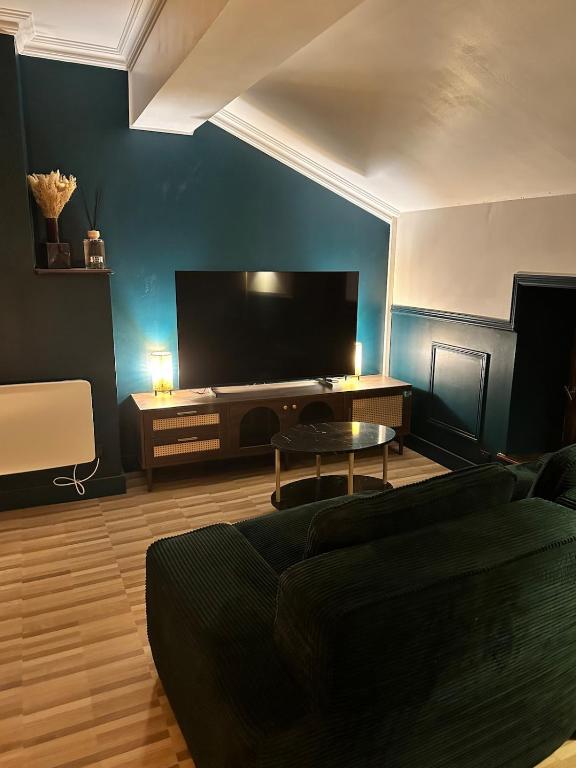 a living room with a couch and a flat screen tv at Escapade Chic in Renwez