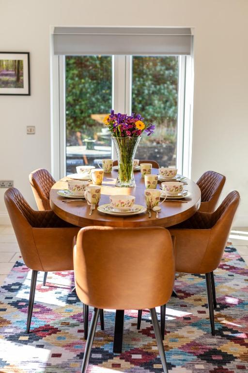 a dining room table with chairs and a vase of flowers at Wild Atlantic Hideaway in Doolin