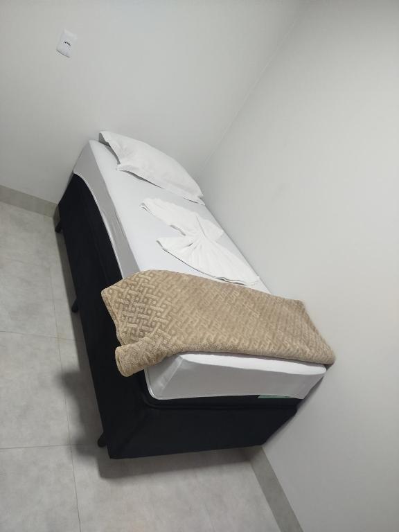 a black and white bed with a pillow on it at DSá Hotel in Cristalândia