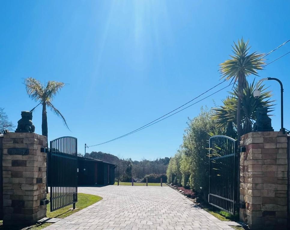 a driveway with a gate and palm trees at Vynmir BeachPark Villa in Fort Bragg
