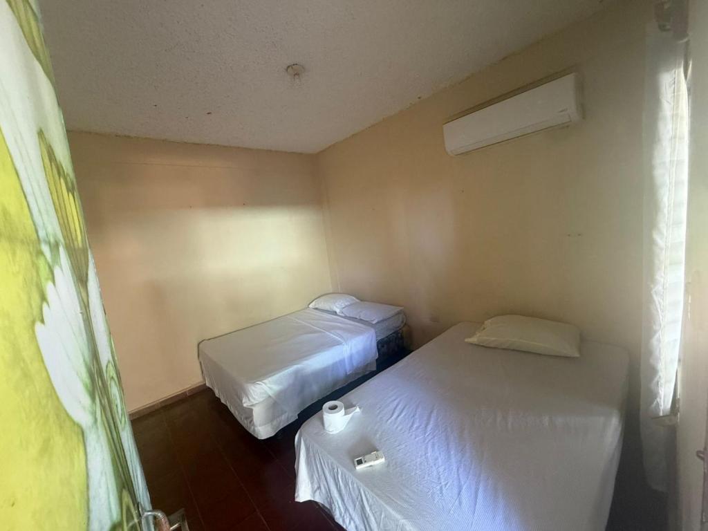 a small room with two beds and a window at Entre olas in La Libertad