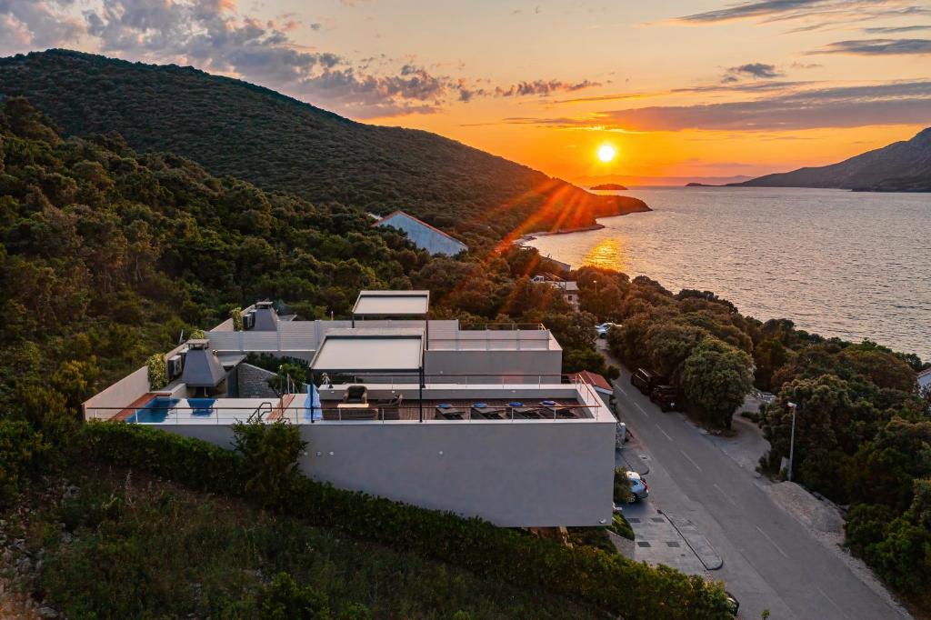 a house on the shore of a lake at sunset at Villa Radman in Korčula