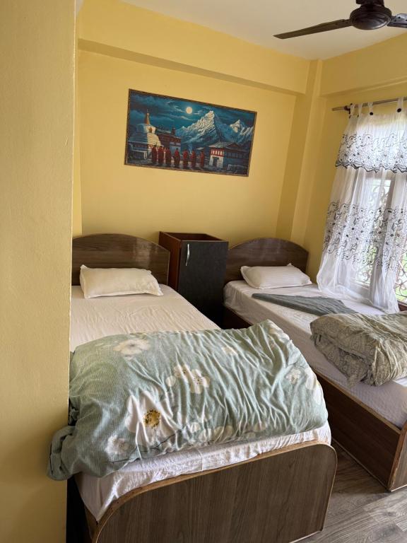 a room with two beds and a painting on the wall at Universal Hotel & Lodge - Gorkha in Gorkhā