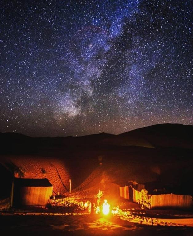 a starry night with the milky way in the sky at Sahara wild camping in Mhamid