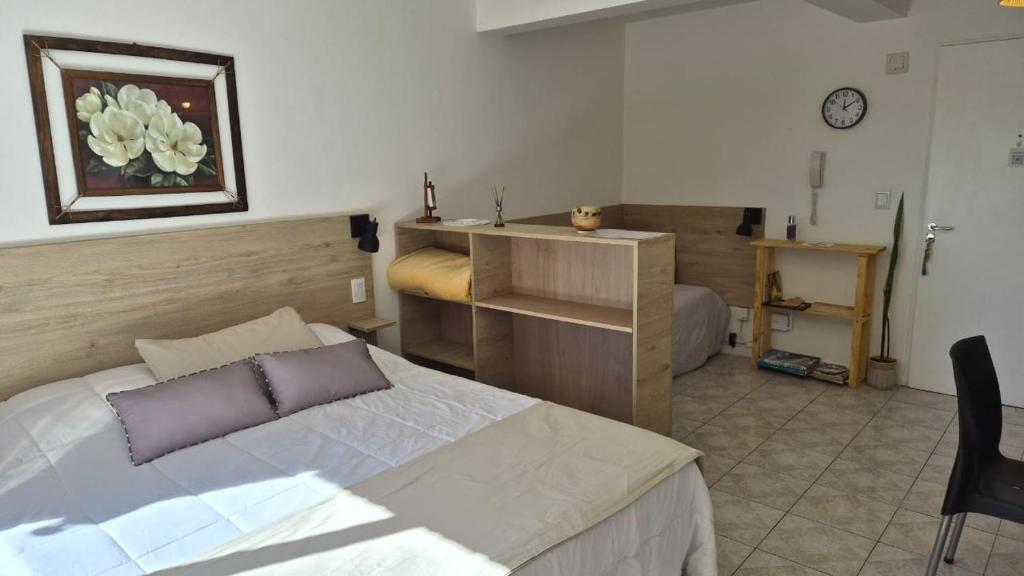 a bedroom with a bed and a desk in it at Solar Andino Inn in San Carlos de Bariloche