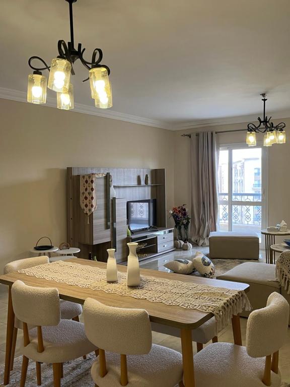 a living room with a table and chairs and a television at Quiet Comfy Stay in Burg el-Ḥudûd