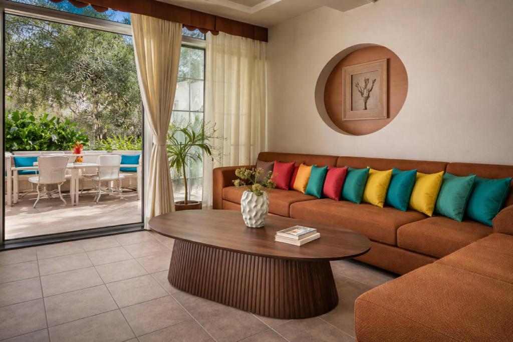 a living room with a couch with colorful pillows at Hotel Dionysis Studios in Adamantas