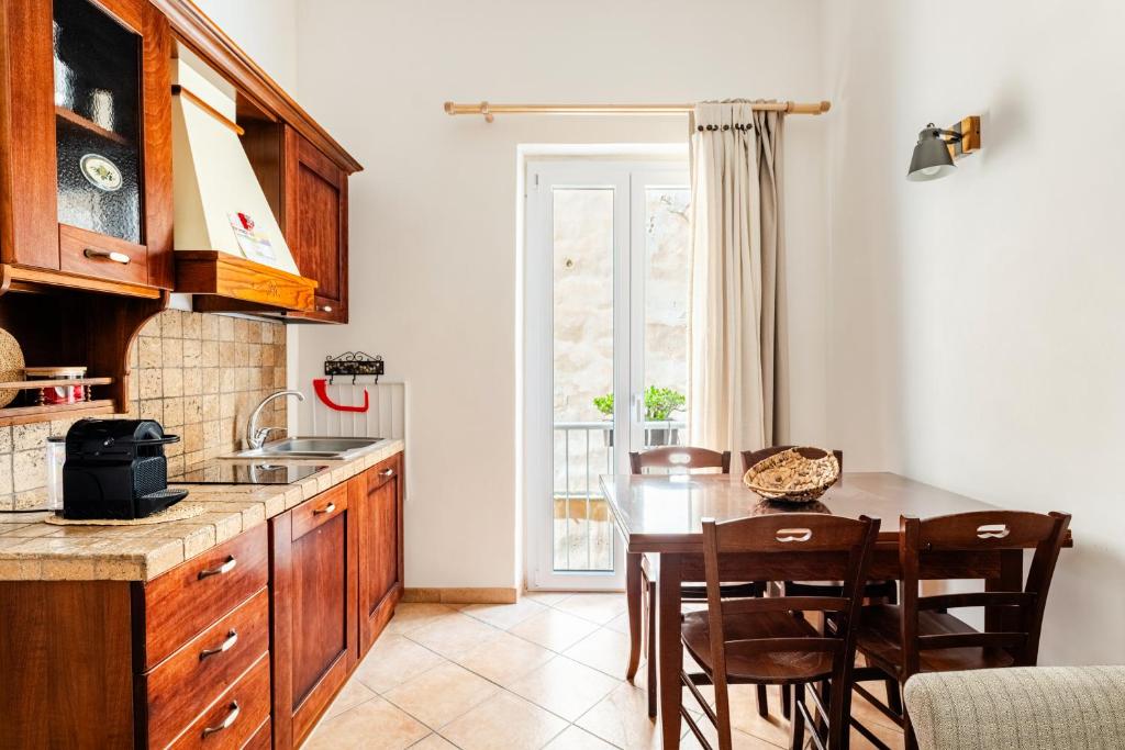 a kitchen with a table and chairs and a dining room at Vicolo 35 Apartments in Trapani