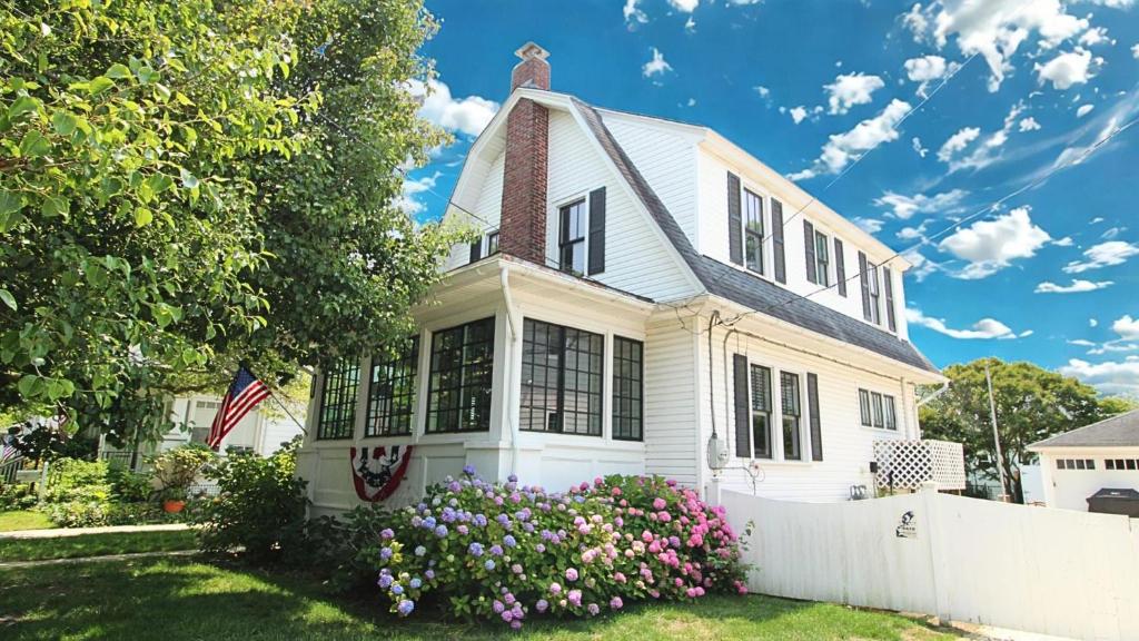 a white house with a white fence and flowers at Windsor Escape in Cape May