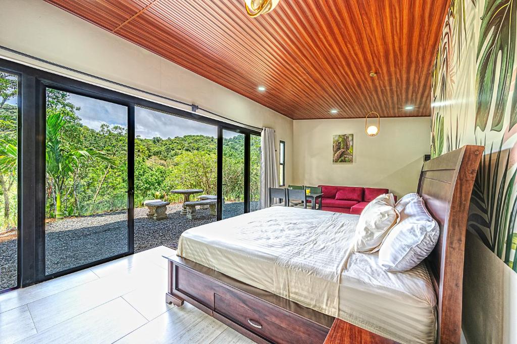a bedroom with a bed and a large window at Mountain Whisper in Tilarán