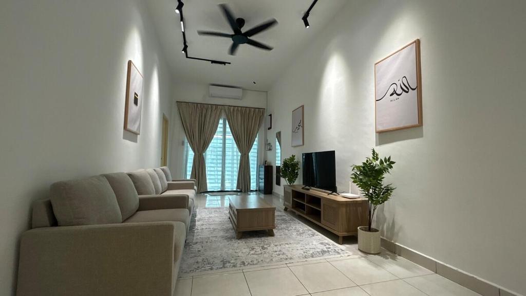 a living room with a couch and a tv at Zahran Homestay in Papar