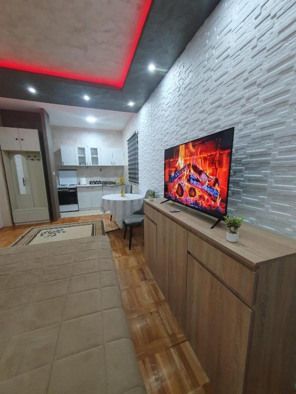 a living room with a flat screen tv on a brick wall at Trend Lux Obrenovac, sa parkingom in Obrenovac