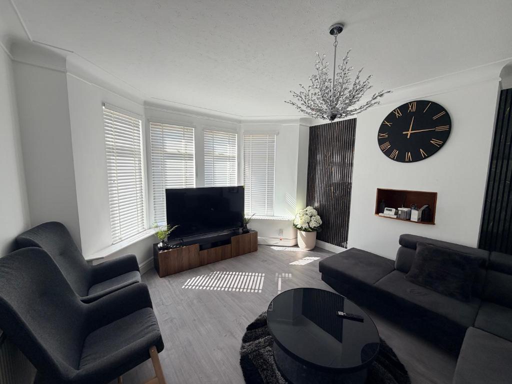 a living room with a large clock on the wall at The Alcove Retreat in Bristol
