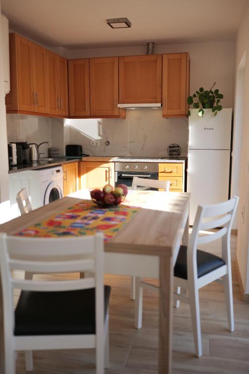 a kitchen with a table and chairs and a white refrigerator at Casas Luar da Aldeia - Apartamentos in Odeceixe