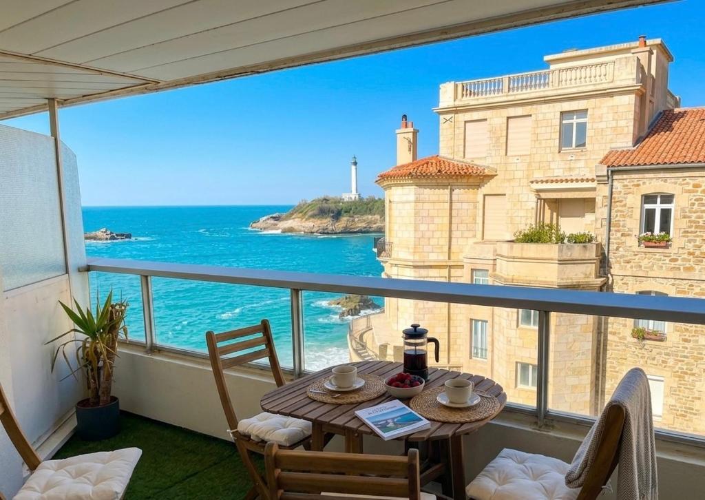 a table on a balcony with a view of the ocean at Prince Studio front de mer - residence luxe & thalasso in Biarritz