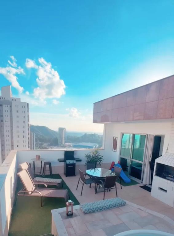 a balcony with a table and chairs on a building at Cobertura Espetacular no Belvedere com Jacuzzi in Belo Horizonte
