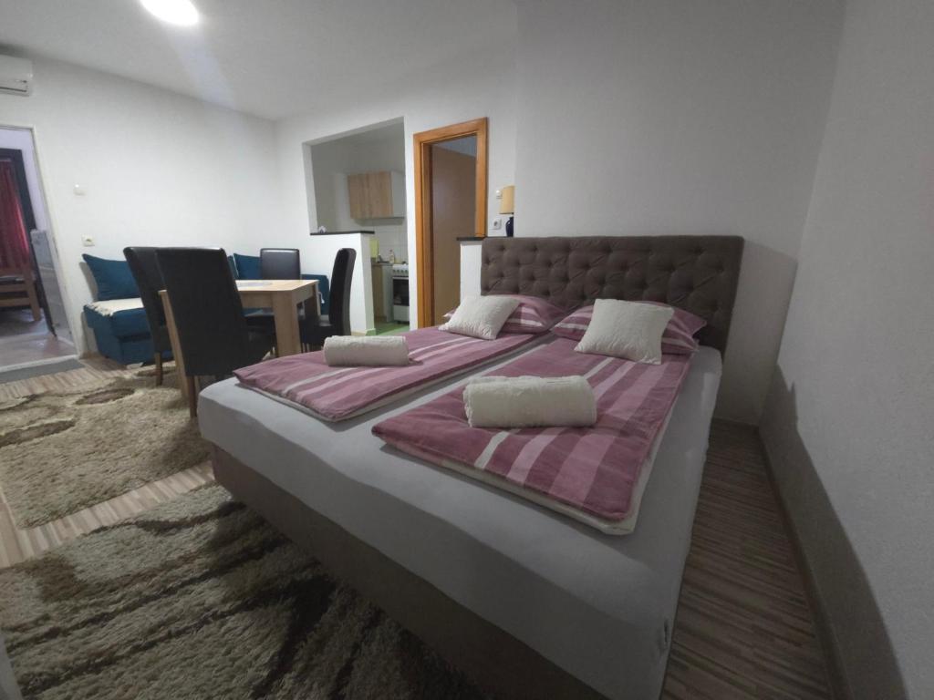 a bedroom with a large bed with purple sheets and pillows at Guest House Nana in Mostar
