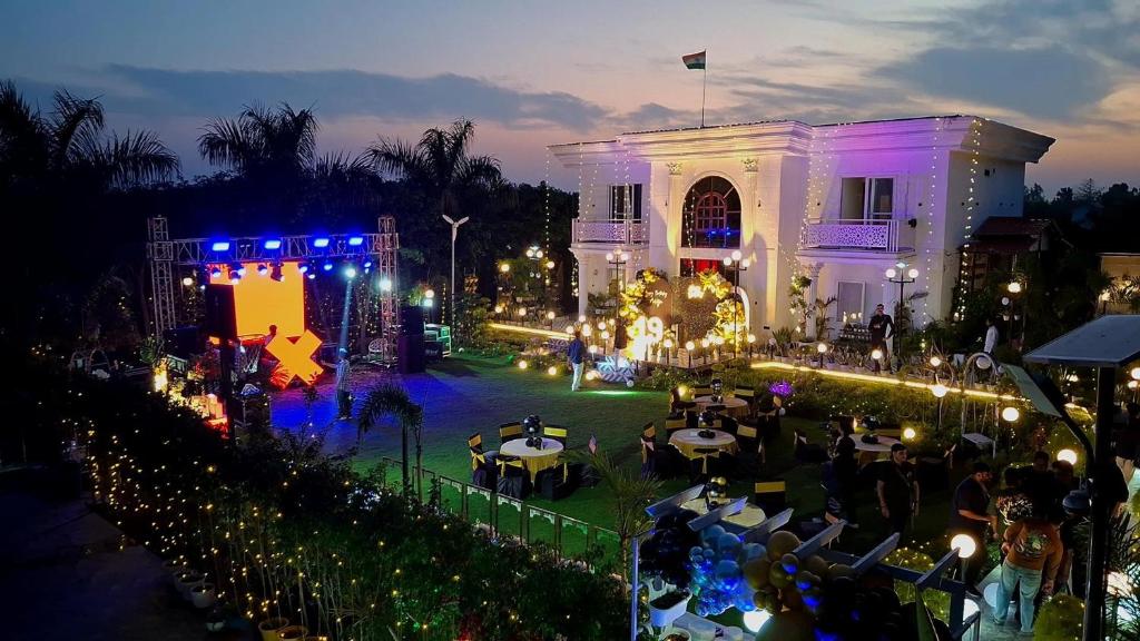 an outdoor event with tables and lights at night at Raskunj Farm in Noida