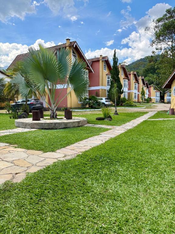 a palm tree in a park next to a house at BeInn - Short Stay Collection Penedo in Itatiaia