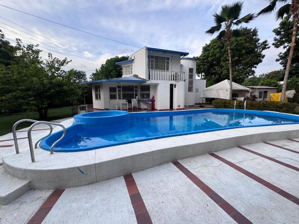 a large swimming pool in front of a house at Ricaurte casa campestre in Ricaurte