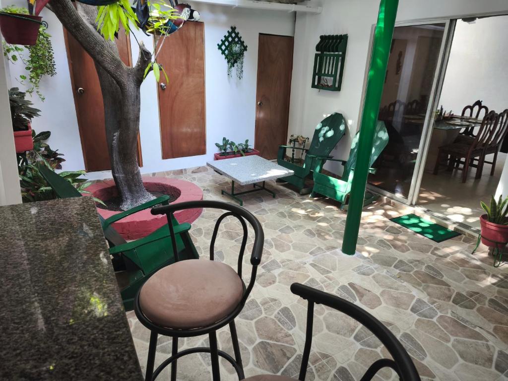 a room with chairs and a tree and a table at Casa Aranza in Cartagena de Indias
