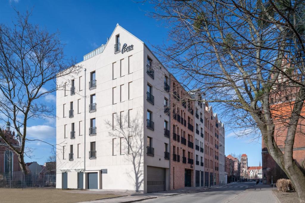 a white building on the side of a street at Prize by Radisson, Gdansk in Gdańsk