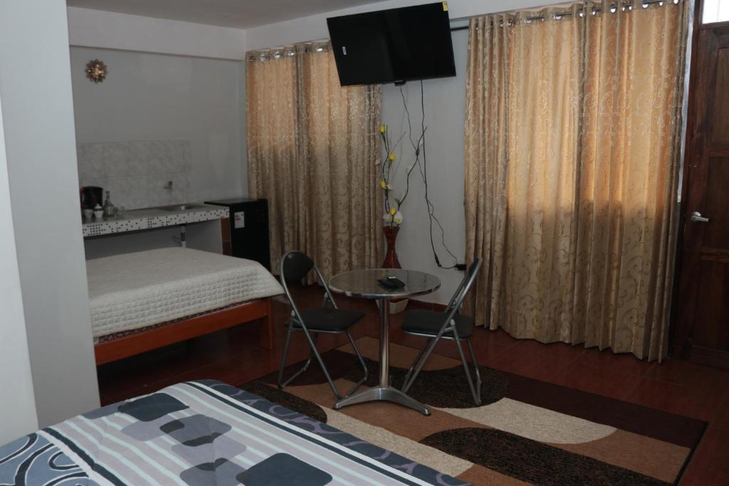 a bedroom with a bed and a table and chairs at Lechugal Guest House in Cusco