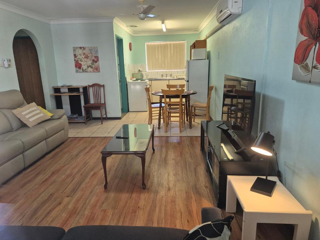 a living room with a couch and a table at Fully Airconditioned Geraldton Holiday Unit with free Streaming in Geraldton