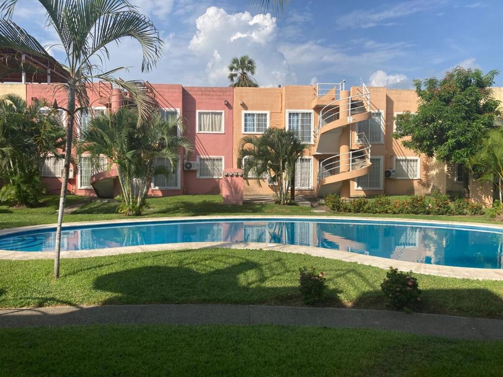a house with a swimming pool in front of a building at Casa Tortuga in Ixtapa
