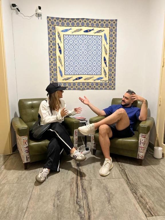 a man and a woman sitting on a couch at Varandas do Chiado - Coliving in Lisbon