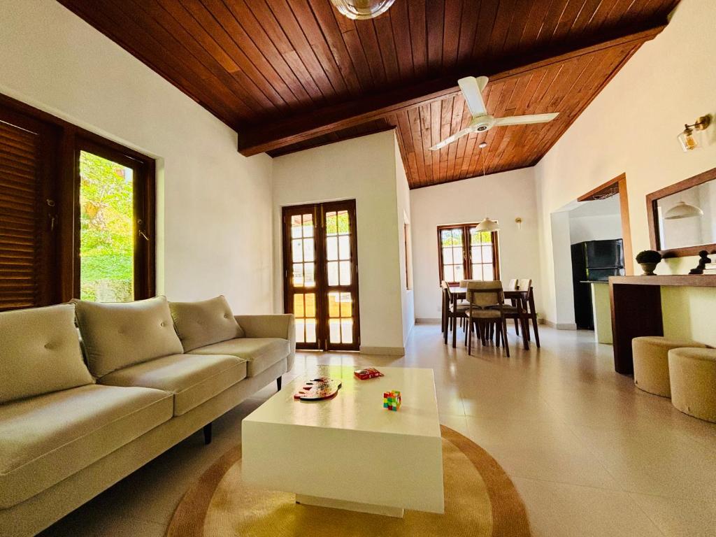 a living room with a couch and a coffee table at Citron Cottage in Kandy