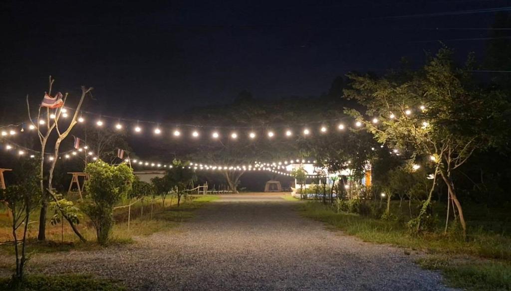 a lit up driveway with lights at night at ใจฟูฟู พูลวิลล่า in Ban Khok Kratai (1)