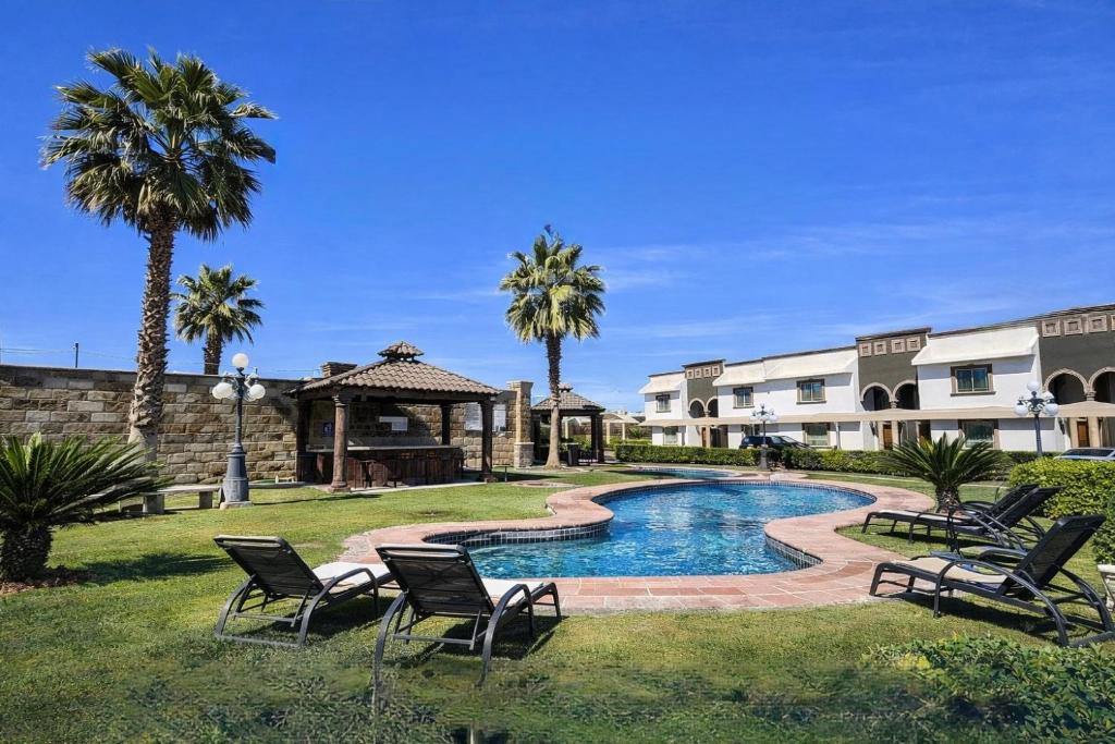 a swimming pool in a yard with chairs and a gazebo at Arroyos del Paraíso Residencial Suite A in Manuel F. Martínez