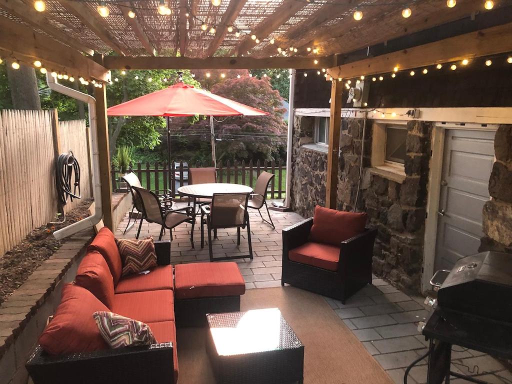 a patio with a table and chairs and an umbrella at Little haven by the woods in Peekskill