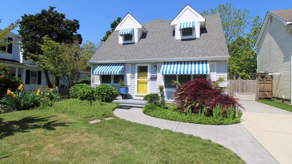 a house with a yellow door and a yard at The Roost Ii On Leaming in West Cape May