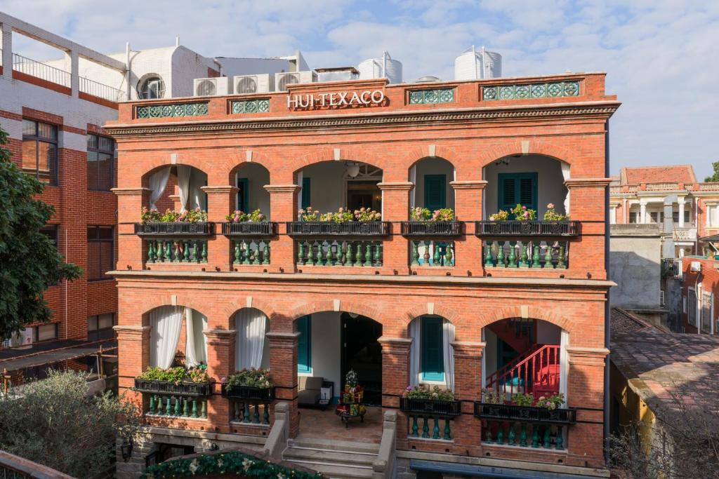 a brick building with flower boxes on the balconies at Hui-TEXACO in Gulang Yu