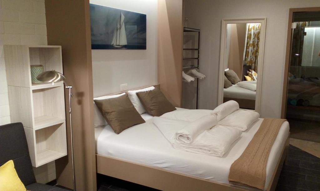 Schlafzimmer mit einem Bett mit weißer Bettwäsche und Kissen in der Unterkunft Bed aan zee Kabine7 in Koksijde