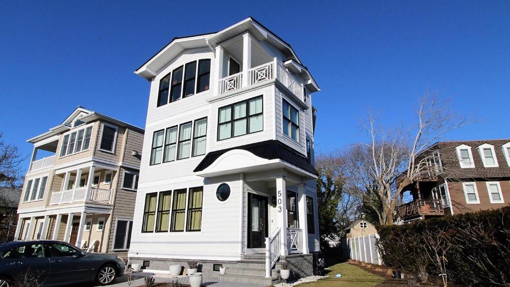 a white house with a car parked in front of it at 12 Pearls in Cape May Point