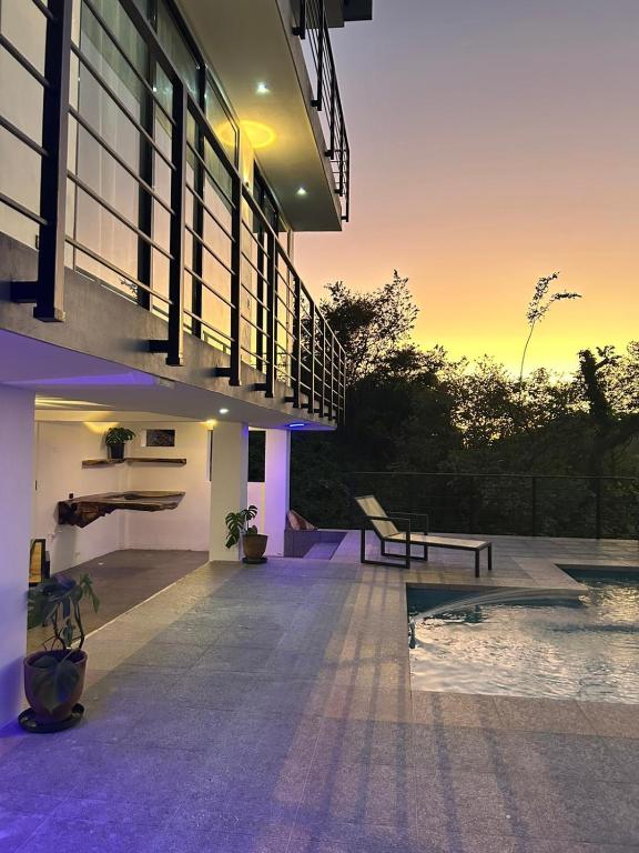 a view of a house with a pool at sunset at Casa Elio - Bed and Breakfast in San Juan del Sur