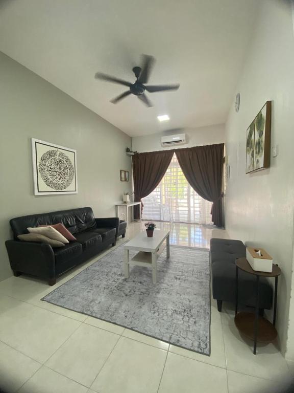 a living room with a couch and a ceiling fan at Impian May Homestay 1,Taman Koperat Putera in Kampung Raja