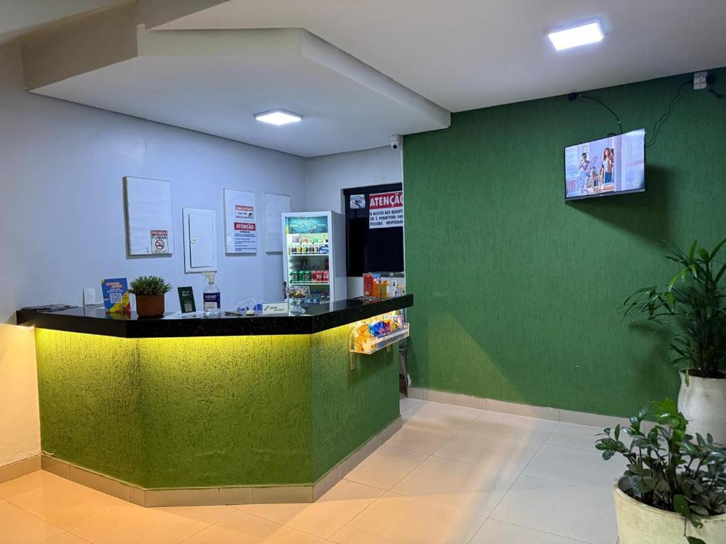a store with a green wall and a counter at Hotel 44 Oliveira in Goiânia